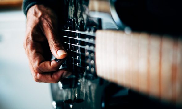 history of guitar feature - stock photo of person playing guitar