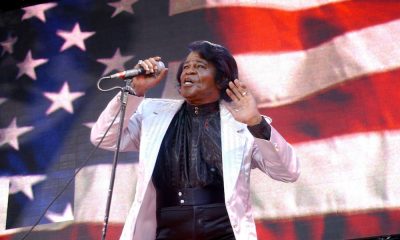 James Brown, singer of the patriotic song and 4th of July anthem Living in America, singing in front of an American flag