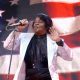James Brown, singer of the patriotic song and 4th of July anthem Living in America, singing in front of an American flag