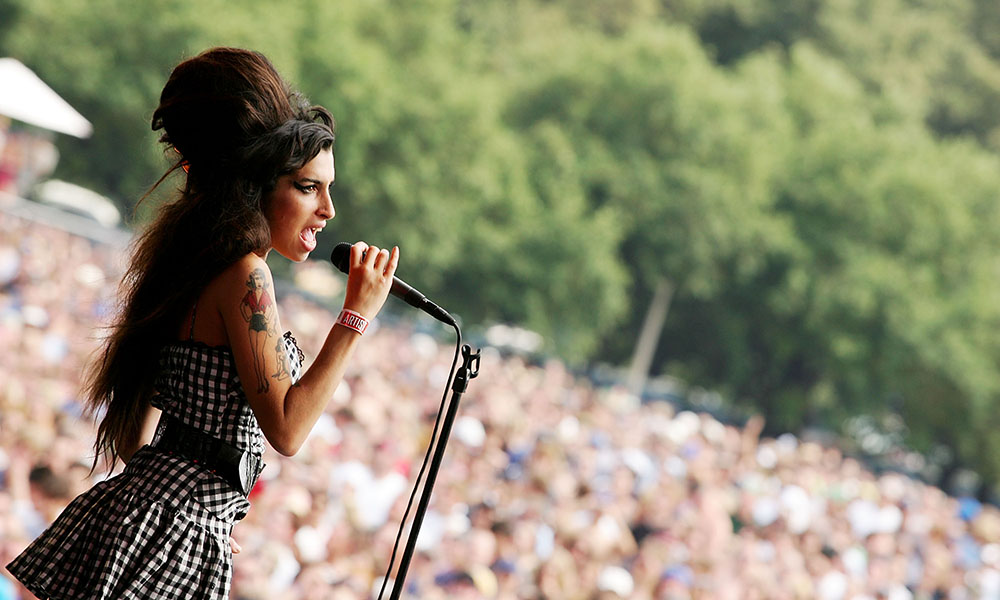 Amy Winehouse singing in front of a crowd.