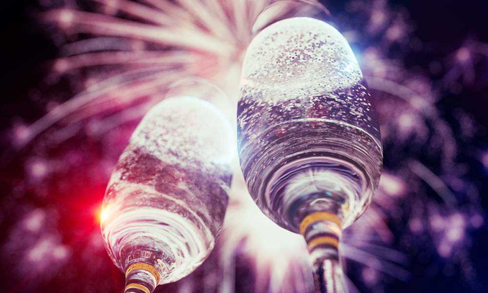 Best Classical Music for New Year - featured image of champagne glasses and fireworks