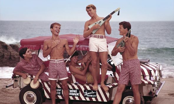 Folks playing surf rock music on a beach