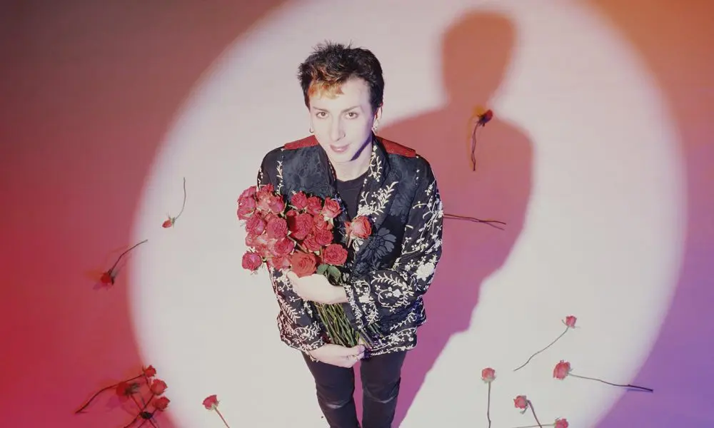 Marc Almond of Soft Cell looking up at the camera holding roses