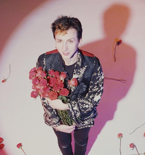 Marc Almond of Soft Cell looking up at the camera holding roses