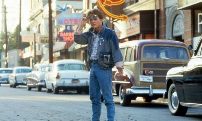 Michael J Fox walking across the street in a scene from the film 'Back To The Future', a movie with a classic 1980s soundtrack